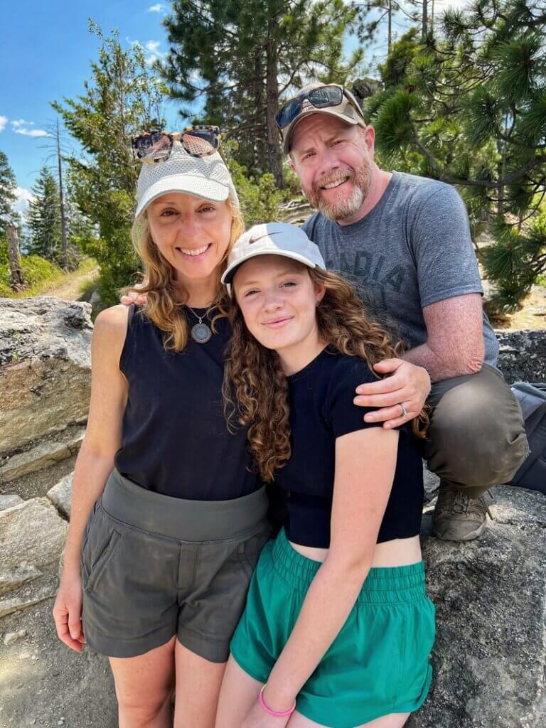 A mom and dad with daughter at the Blodgett Canyon Overlook summit in Montana in the Bitterroot National Forest. Credit: Gatherandgotravel.com